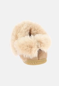 Pantofole beige con parte superiore morbida e pelosa e materiale in suede morbido, con suola in gomma testurizzata per una presa migliore. Forma arrotondata, design minimalista.