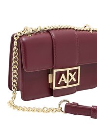 Borsa a tracolla in pelle bordeaux con catena dorata, pattina frontale e chiusura rettangolare con logo "AX". Texture liscia con cuciture definite.