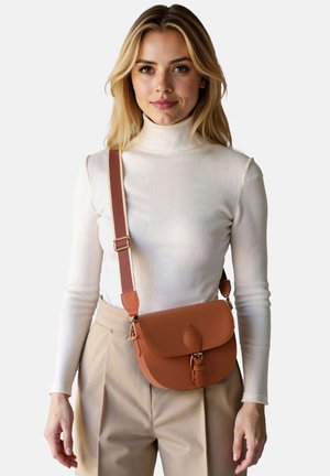 Hnědá kožená crossbody taška s klopou, sponou ve tvaru listu a nastavitelným popruhem. Hladký povrch a minimalistický design.
