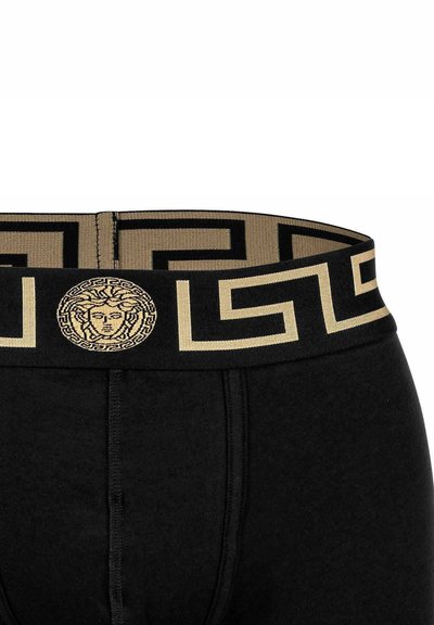 Black cotton boxer briefs with a gold and black patterned waistband featuring a Medusa emblem and geometric designs.