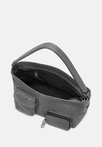 Sac en cuir gris avec une seule anse, fermeture éclair et poches intérieures. Dispose de deux compartiments extérieurs zippés pour un espace de rangement supplémentaire.