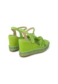 Sandali wedge in suede verde con dettaglio a nodo sul davanti, cinturini regolabili e una suola intermedia testurizzata e decorata.