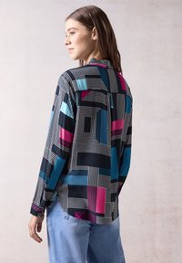 Camicia a maniche lunghe con un motivo geometrico in nero, blu e rosa, dal fit rilassato e con dettagli del colletto a contrasto.