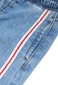 Denim shorts in een lichtblauwe kleur, met zijzakken en rood-witte gestreepte accenten aan de zijkanten. Ge structures stof met zichtbare stiksels.
