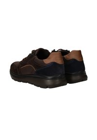 Vue arrière de chaussures multi-matériaux marron, présentant une combinaison de daim et de cuir, des accents contrastants et une semelle en caoutchouc texturée.