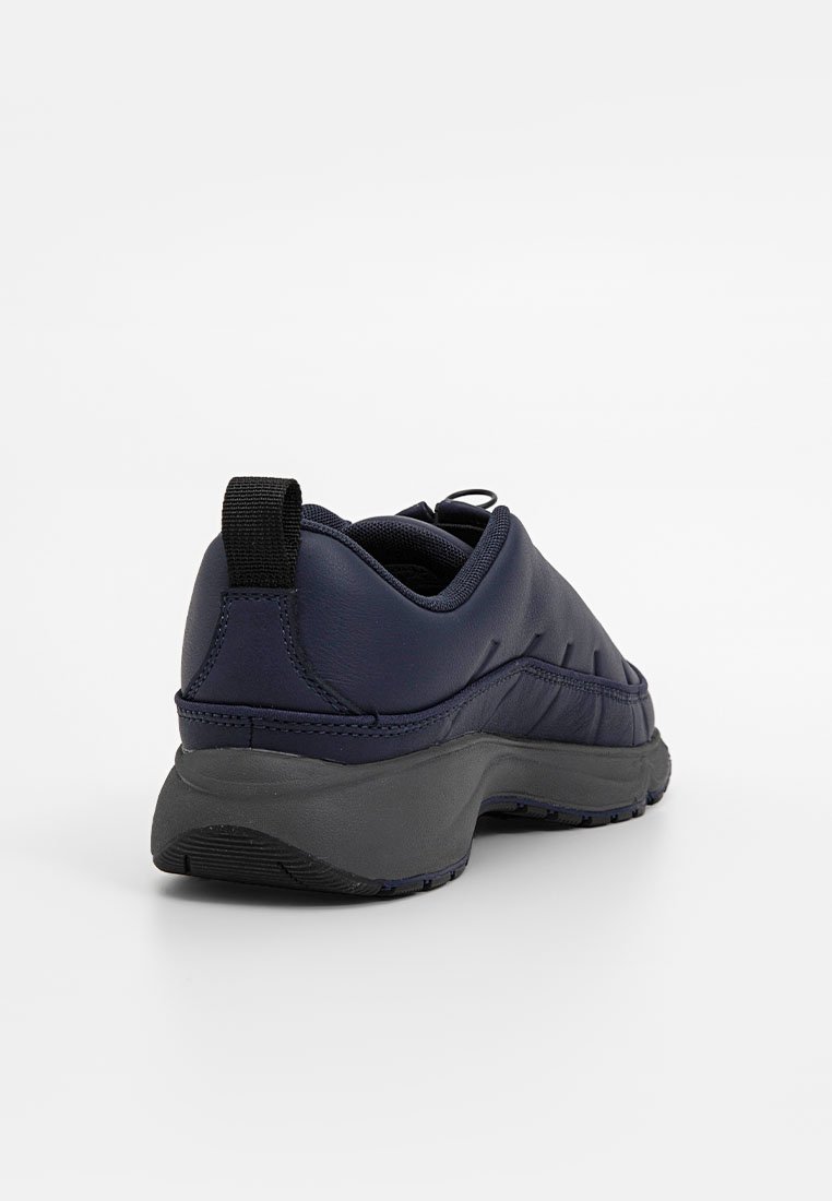 Zapatillas deportivas azul marino con parte superior texturizada, cuello acolchado, una lengüeta en el talón y una suela gruesa de goma negra.