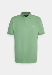 Zelené polo tričko z bavlněné tkaniny, s klasickým límcem, zapínáním na tři knoflíky, krátkými rukávy a malým růžovým logem na levé straně hrudníku.