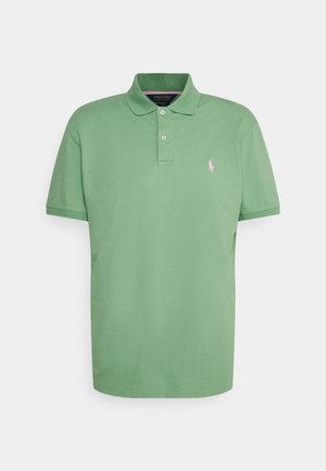 Grön polo skjorta i bomullstyg, med en klassisk krage, treknapplås, korta ärmar och en liten rosa logotyp på vänster bröst.
