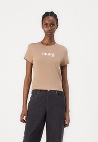 Light brown cotton t-shirt with short sleeves, featuring white graphic designs of a cactus, sun, wave, and hand on the front.