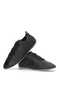 Zapatillas de cuero negro con un acabado texturizado, cordones planos, suelas de goma delgadas y un diseño de perfil bajo, que cuentan con una puntera redondeada.