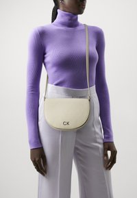 Calvin Klein DAILY SADDLE BAG MONO - Borsa a tracolla - stoney beige