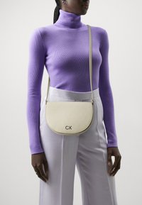 Calvin Klein - DAILY SADDLE BAG MONO - Geantă crossbody - stoney beige Imagine miniatură 1