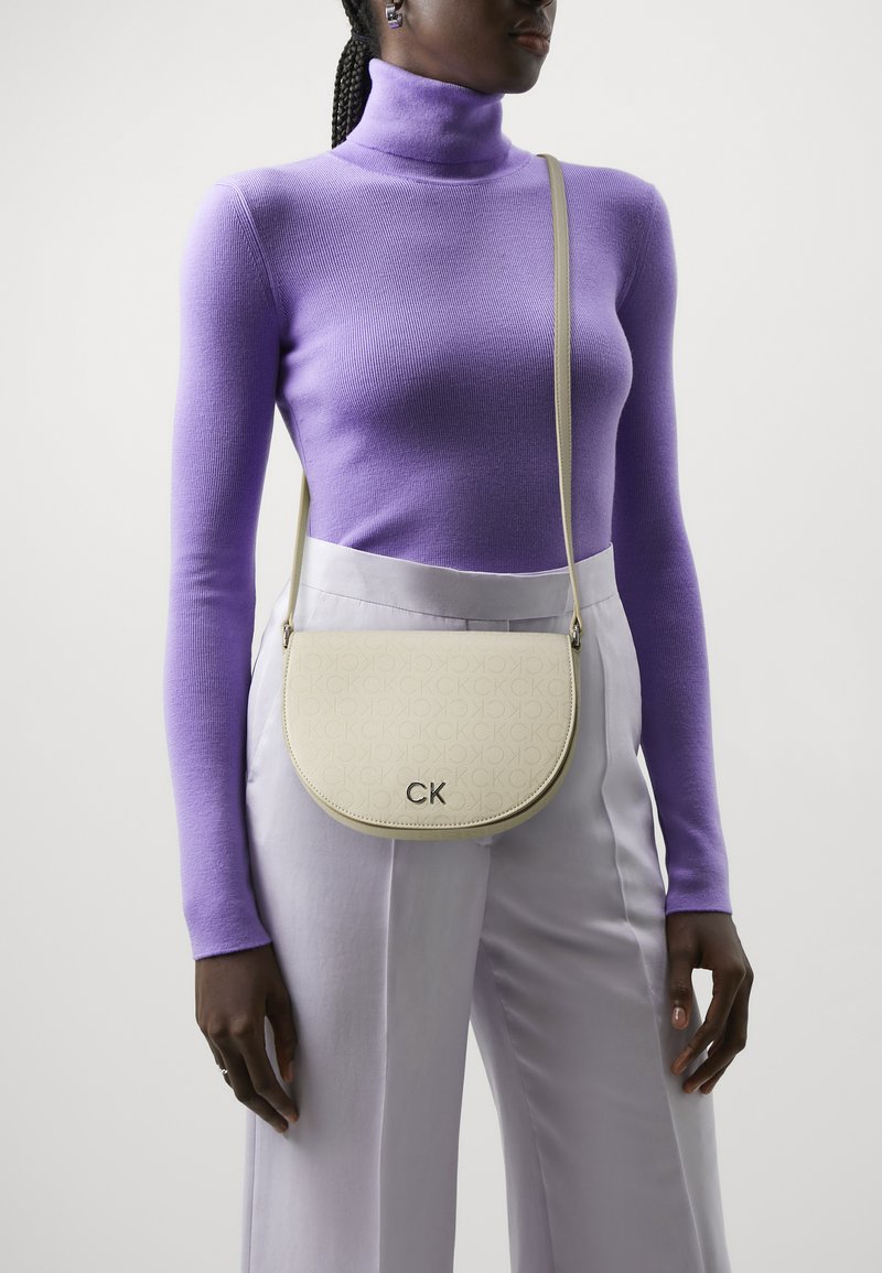 Calvin Klein - DAILY SADDLE BAG MONO - Geantă crossbody - stoney beige, Extindeți