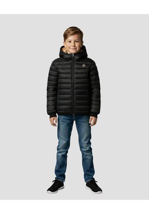 Zwarte donzen jas met capuchon, ritssluiting en horizontale stiksels. Gedragen over een blauwe spijkerbroek en zwarte sneakers. Kind staat met ontspannen armen.