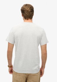 Grå bomulds T-shirt med en klassisk rund hals, korte ærmer og et enkelt design, der fremhæver bagsiden.