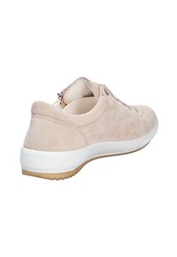 Béžové semišové tenisky s zaoblenou špičkou, bílou střední podrážkou a texturovanou gumovou podrážkou. Mají boční zip a šněrování na přední straně.