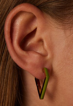 Green and gold geometric earrings, featuring a V shape with glossy finish and contrasting gold-tone hardware, attached to the ear.