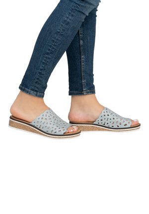 Light blue patterned slide sandals with a cork sole and white rubber outsole, featuring an open toe and cut-out design.