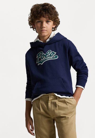 Granatowa bluza z kapturem z logo "Polo Ralph Lauren", wykonana z bawełny, z kieszenią kangurką, w połączeniu z beżowymi spodniami z zakładkami.