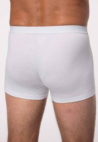 Boxer brevi bianchi in cotone con una morbida vita elastica, texture liscia e un design aderente, con cuciture minime e senza modelli visibili.