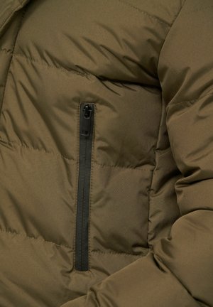 Olivgrüne Steppjacke mit weicher, glatter Textur, horizontaler Steppung und einer Reißverschlusstasche auf der linken Seite.