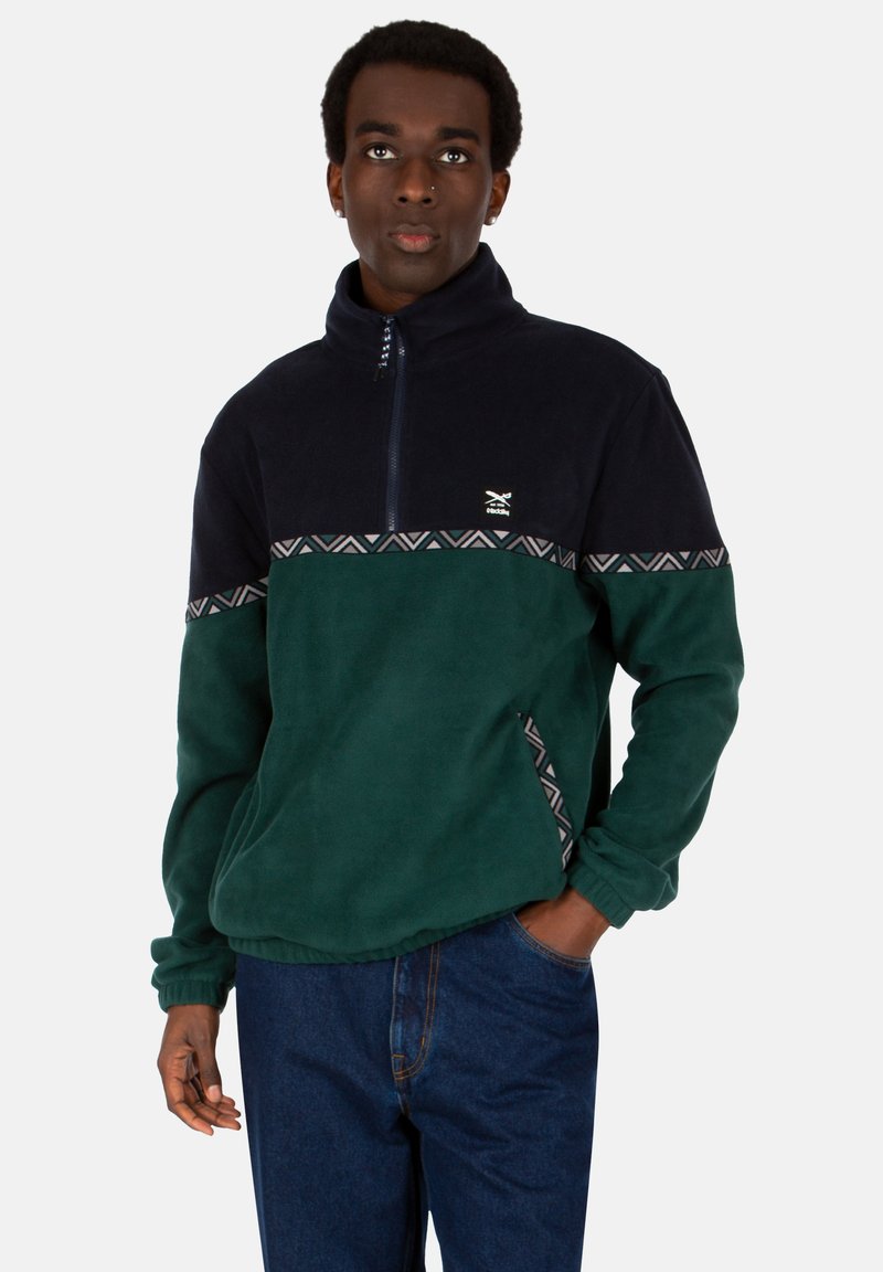 Dunkelnavy und forstgrüner Fleece-Pullover mit halbem Reißverschluss, geometrischem Muster, seitlichen Taschen und lässiger Passform.