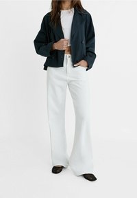 Granatowa, krótką podwójną marynarkę połączoną z białymi, wysokimi dżinsami w kształcie dzwonów i czarnymi, spiczastymi balerinami. Gładki materiał o luźnym kroju.