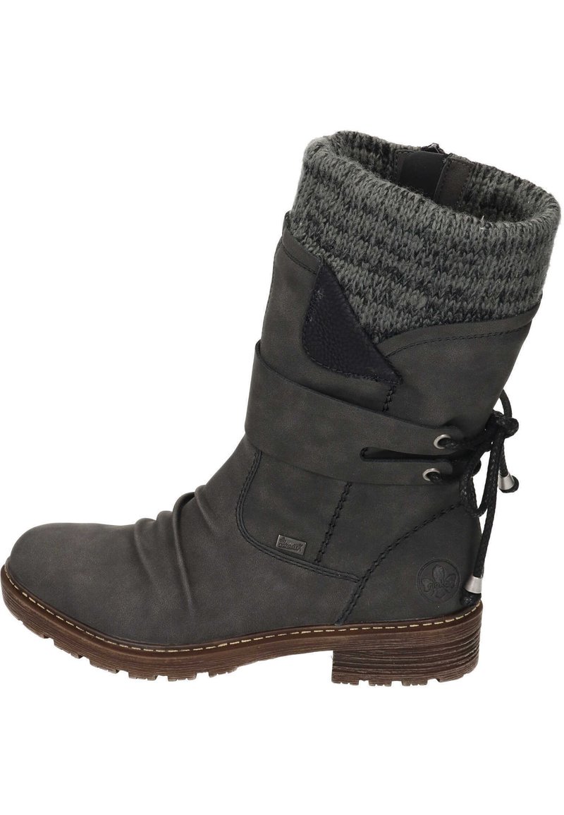 Bottine en cuir gris avec une tige tricotée grise, des lacets sur le côté et une semelle texturée. Elle présente un petit logo sur le côté et des détails de couture.