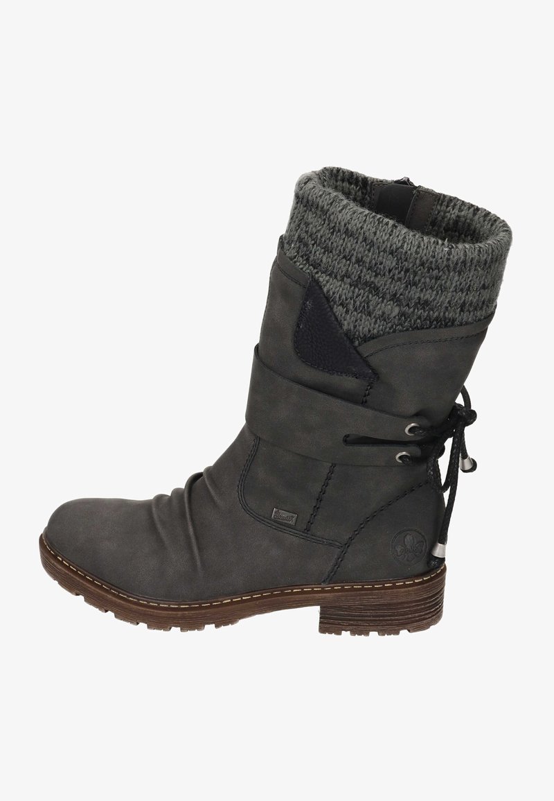 Bottine en cuir gris avec une tige tricotée grise, des lacets sur le côté et une semelle texturée. Elle présente un petit logo sur le côté et des détails de couture.