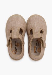 Beige fabric shoes with a textured surface, round toe, and adjustable strap. Light sole with visible stitching and brand logo inside.
