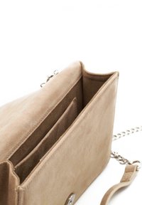 Bolso de ante beige con un diseño sencillo, que cuenta con una correa de cadena, pequeños bolsillos en el interior y un cierre metálico a presión.