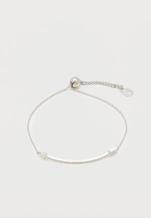 Ασημένιο ρυθμιζόμενο βραχιόλι αλυσίδας με καμπυλωτή μπάρα διακοσμημένη με μικρά διαυγή κρύσταλλα σε λευκό φόντο.