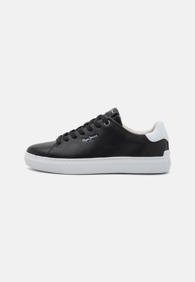 Czarne syntetyczne sneakersy z białym akcentem na pięcie, gumową podeszwą, okrągłym noskiem oraz sznurowanym designem z logo po boku i na języku.