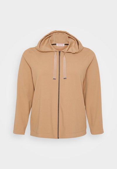 Haut à zip couleur beige avec une capuche à cordon, deux poches à l'avant, texture de tissu douce et un design simple sans embellissements.