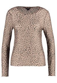 Pitkähiha, kevyt yläosa ruskeassa sävyssä tummilla ruskeilla pilkkuilla. Ominaisuuksiin kuuluu pyöreä kaula-aukko ja hieman löysä istuvuus.