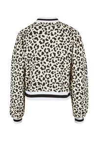 Veste à manches longues avec motif léopard noir et blanc, avec col, poignets et taille rayés noirs et blancs, vue de dos.