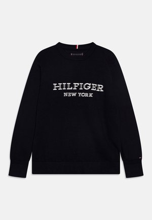 Czarny sweter z długim rękawem i okrągłym dekoltem, z białym haftowanym napisem „Hilfiger New York” na przodzie oraz ściągaczami na rękawach i u dołu.