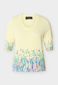 Ανοιχτό κίτρινο πουλόβερ με κοντά μανίκια και στρογγυλή λαιμόκοψη, με πολύχρωμο αφηρημένο σχέδιο κατά μήκος του τελειώματος και των άκρων των μανικιών.