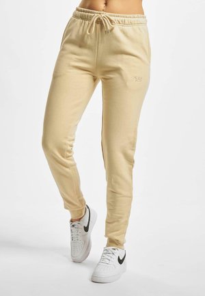 Beige sweatpants met een elastische tailleband en trekkingkoord. Zachte stof, taps toelopende pijpen en geborduurd "DEF" logo aan de voorkant.