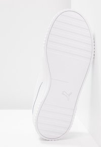 Valkoiset tennarit, joissa on tekstiilinen kumipohja, minimalistinen muotoilu ja huomaamaton logo sivussa. Suora päällinen, jossa on puhtaat linjat.