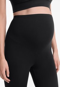 Fekete kismama leggings sima, rugalmas anyagból. Magas derékkal és ferde varrással rendelkezik, ami fittebb megjelenést kölcsönöz.