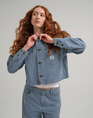 Stripete denimjakke med brune knapper, med grønne detaljer. Kuttet design, kombinert med matchende bukser. Uformell passform, synlige lommer.