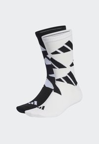 Calcetines de algodón en blanco y negro con un patrón geométrico de formas triangulares, puños acanalados y colores contrastantes en la puntera y el talón.