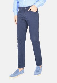 Chinos blu navy con una vestibilità slim, realizzati in cotone, dotati di tasche laterali e chiusura con bottone, abbinati a mocassini in suede azzurro.
