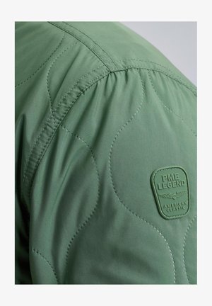 Grüne gepolsterte Jacke mit gestepptem Design, strukturiertem Stoff und einem auffälligen grünen Gummilogo-Patch mit der Aufschrift "PME LEGEND."