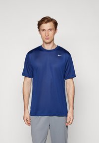 T-shirt de sport Nike bleu à manches courtes, col rond, en tissu léger, arborant un petit logo blanc sur l'épaule gauche.