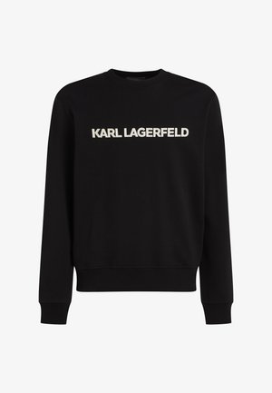 Juodas džemperis, pagamintas iš medvilnės mišinio. Yra raukšlėti rankogaliai, apačia ir didelė balta siuvinėta logo "KARL LAGERFELD" ant krūtinės.