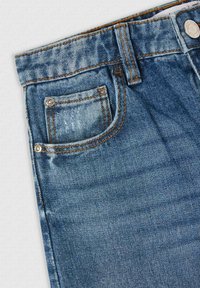 Jeans in denim di colore blu medio, con cuciture arancioni a contrasto e una tasca frontale con dettagli in rivetto metallico.