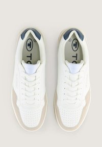 Adidași albi cu accente de piele de nubuck bej, o talpă din cauciuc texturată și detalii bleumarin la călcâi și limbă. Design cu șireturi și perforații.