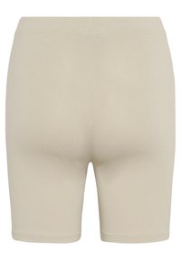 Shorts beige elásticos con una textura suave, de longitud media hasta el muslo y con cintura elástica; sin costuras ni patrones visibles.